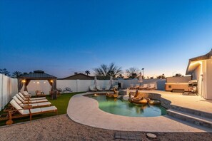 Un jardin avec une piscine, des chaises longues et une pergola.