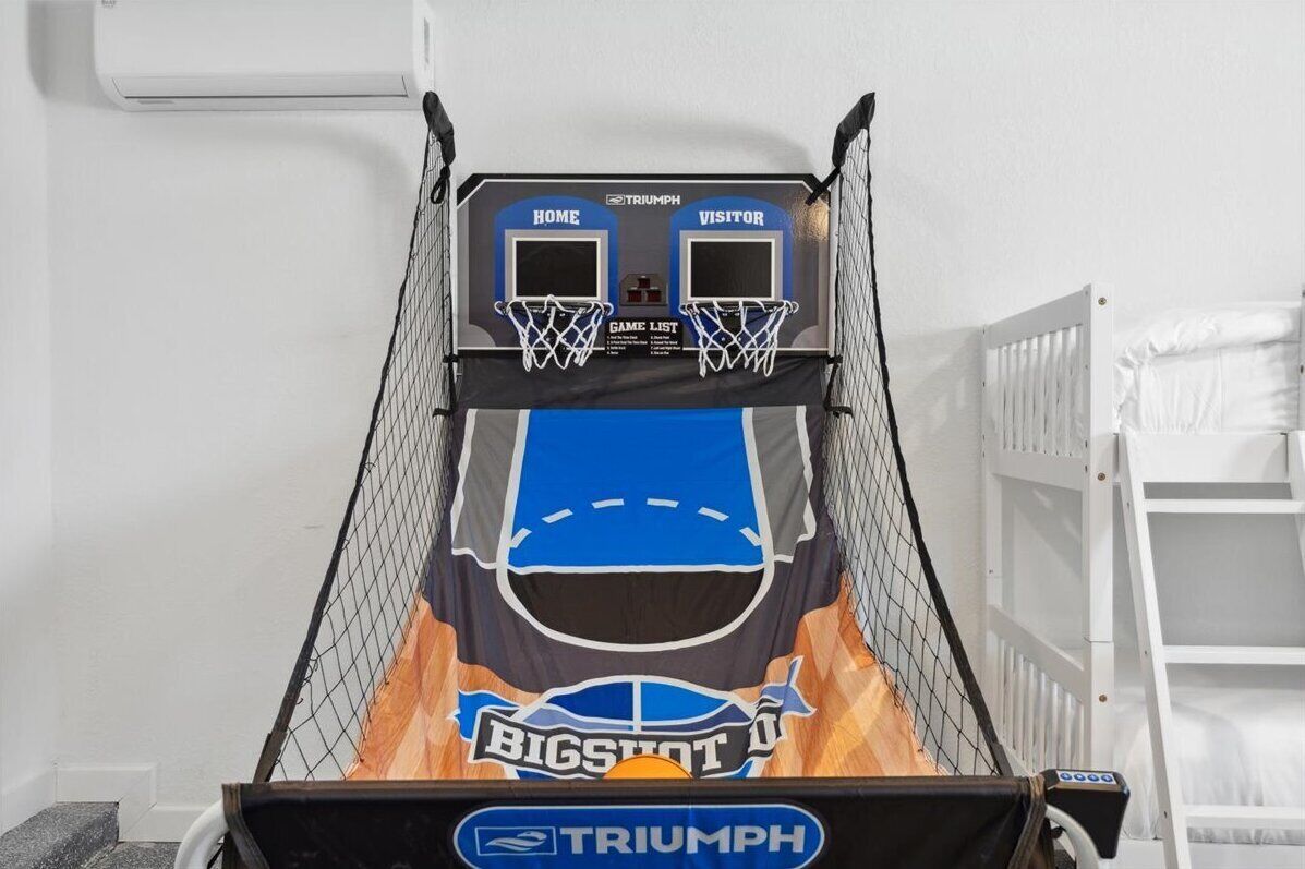 A basketball hoop with a "BIGSHOT" logo, a "TRIUMPH" brand, and a game list sign.