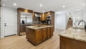 Una cocina moderna con armarios de madera, electrodomésticos de acero inoxidable y encimera de granito.
