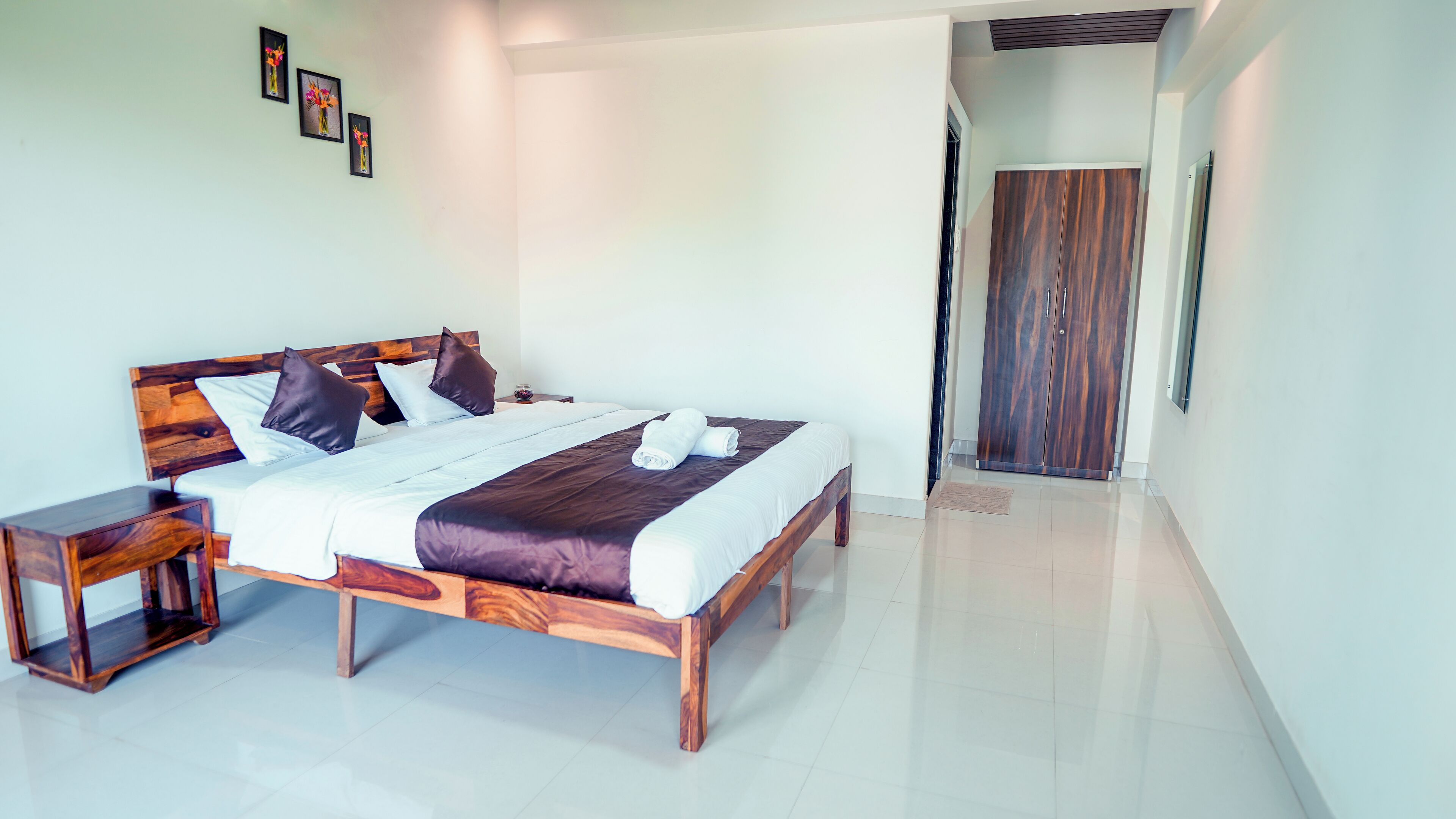 A modern bedroom with a wooden bed, white linens, and a wooden nightstand.