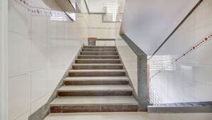 Una escalera con escalones y paredes de mármol que lleva a un rellano con una puerta.