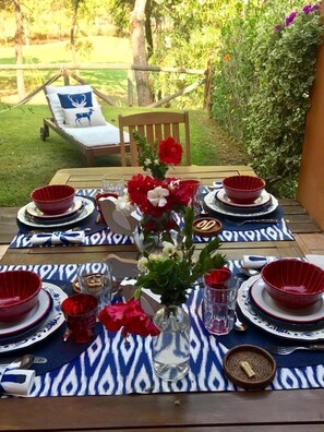 Enjoy al fresco dining in a serene garden setting with a beautifully set table for four.
