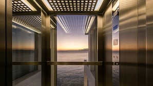 Un ascenseur offrant une vue sur un coucher de soleil sur l’eau.