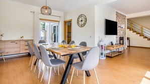 Una cocina moderna con comedor, suelo de madera y un televisor montado en la pared.