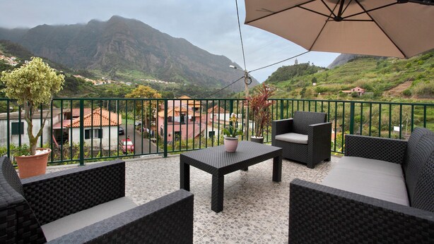 Un balcon aménagé avec du mobilier d’extérieur, une table et une plante en pot.