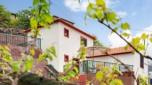 Un bâtiment blanc avec des ornements rouges, un balcon et un escalier.
