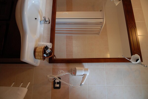 A bathroom with a sink, a mirror, a towel rack, and a toilet paper holder. - Farmhouse Cabin (STELLA CILENTO)