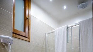 Moderni kylpyhuone, jossa on lasinen suihkuseinä, kaksi pesuallasta, bidee ja wc.