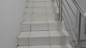 Een trap met witte treden en een metalen leuning.
