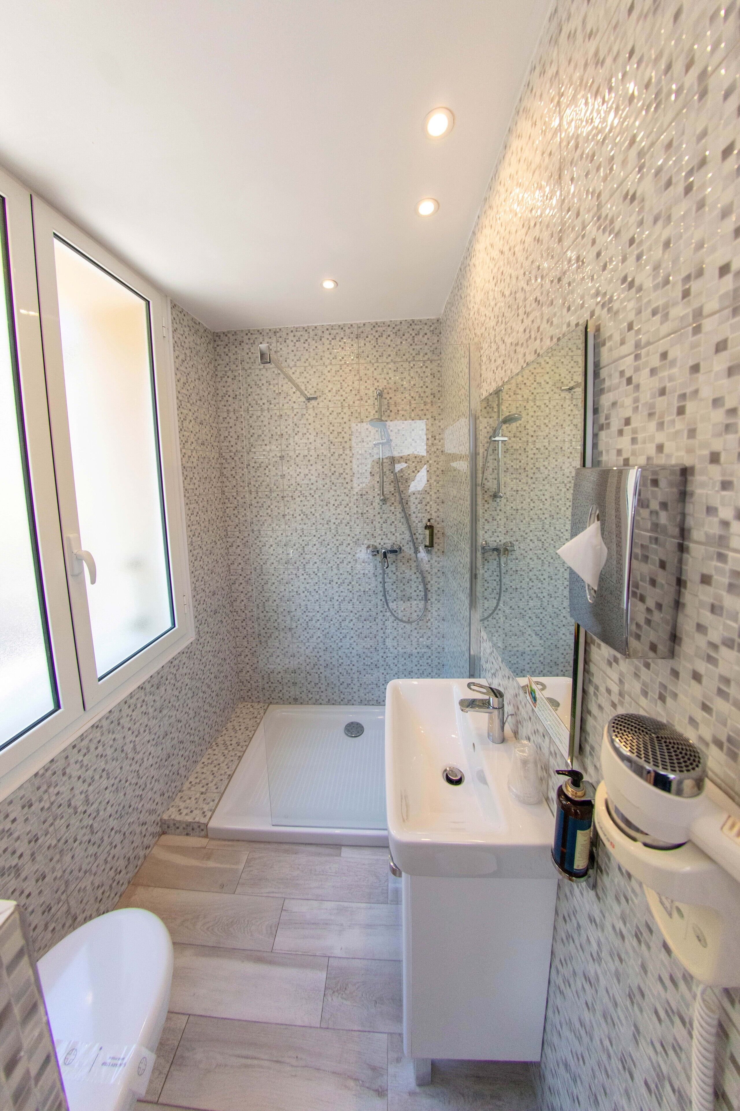 Une salle de bain moderne équipée d’une douche, de toilettes et d’un lavabo.