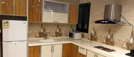 Une cuisine moderne avec des meubles en bois, un four à micro-ondes encastré, un évier et un crédence décorative.