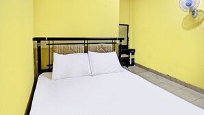 A bed with white linens in a room with yellow walls and a black headboard. - Hotel O Kos Agi Mataram Near Masjid Hissoh Al-Faham (Mataram)