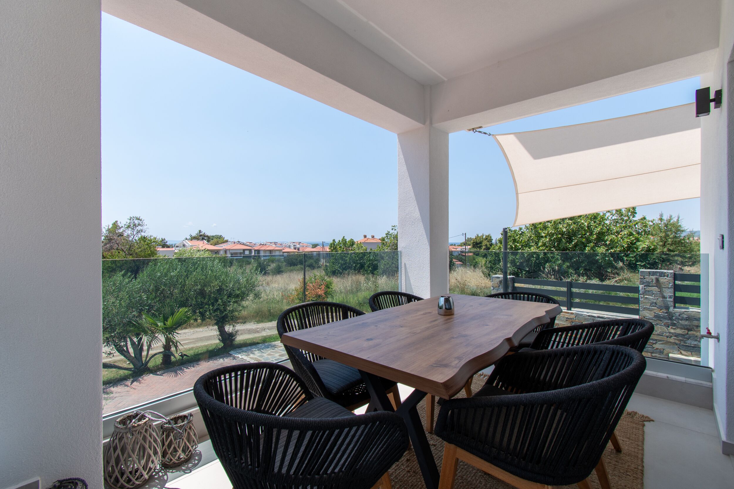 A balcony with a table and chairs, offering a view of the surrounding landscape.