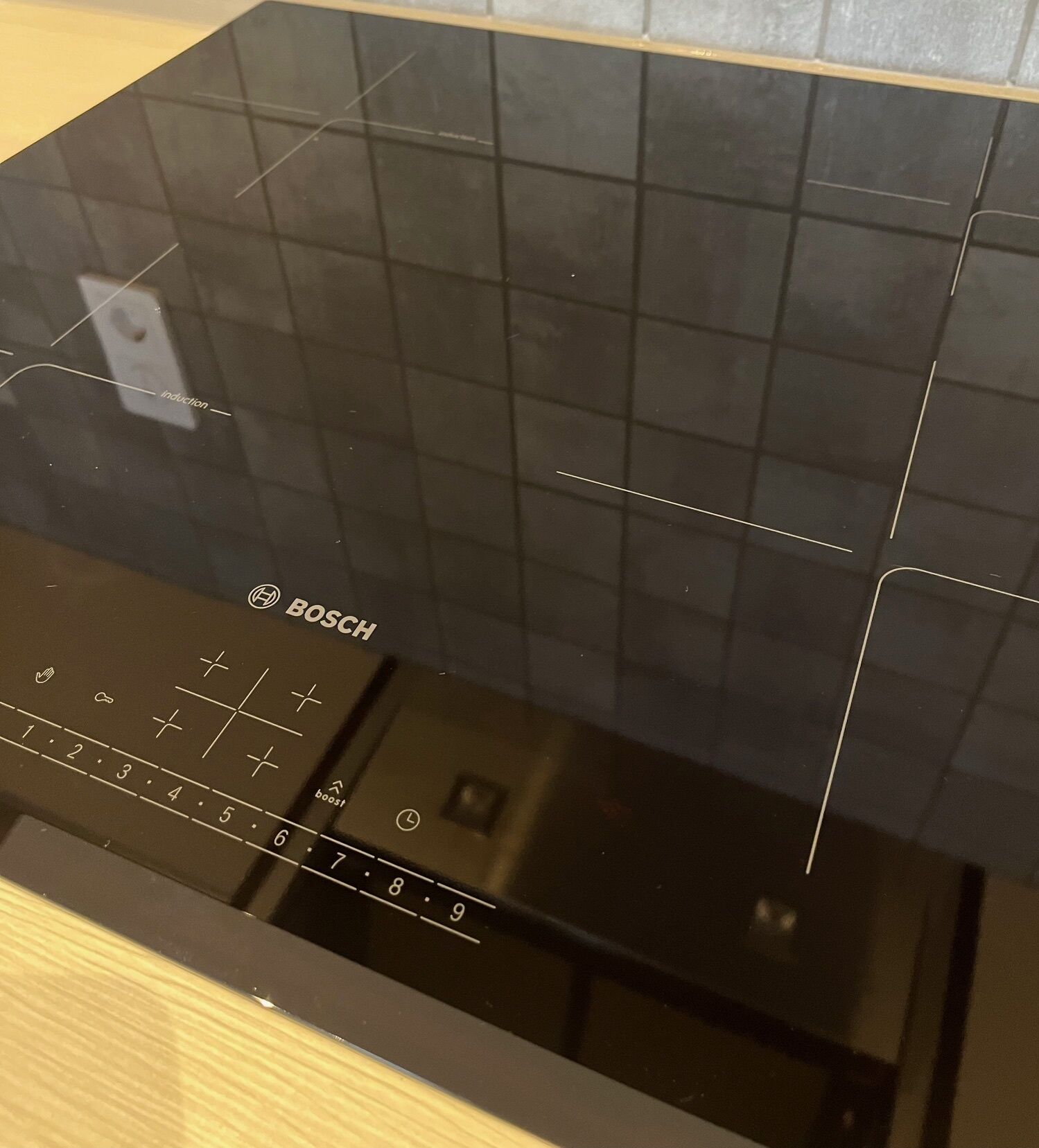 A Bosch induction cooktop with control panel and touchpad.