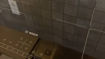 A Bosch induction cooktop with control panel and touchpad.