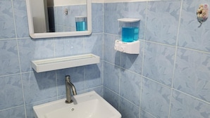 A bathroom with a white sink, a mirror, and two shelves with blue containers. - Jipu Homestay (Betong)