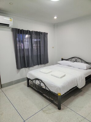 A single bed with a metal frame, white bedding, and a grey curtain. - Jipu Homestay (Betong)