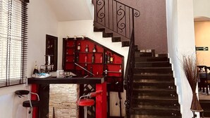A modern interior with a staircase, a bar area, and a dining space. - BATES GARDEN GUEST HOUSE (Lekki)