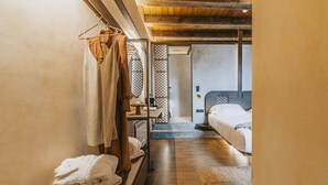 A narrow hallway leading to a bedroom with a wooden ceiling, a bed, and a small table with a lamp. - Oniros Residenza Vecchia  (Chania)