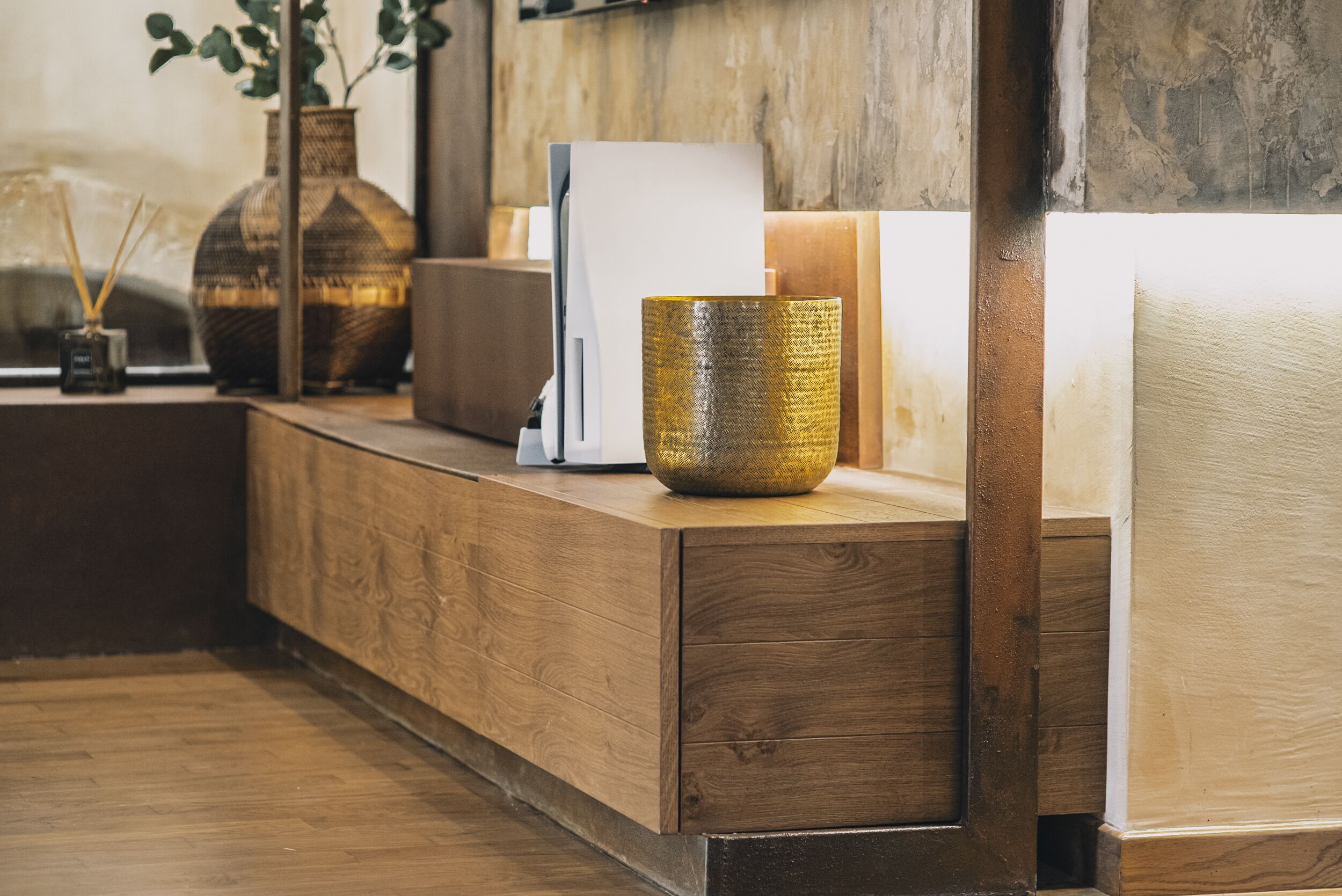 A wooden reception desk with a vase, a whiteboard, and a small plant.