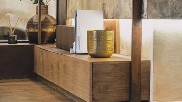 A wooden reception desk with a vase, a whiteboard, and a small plant.
