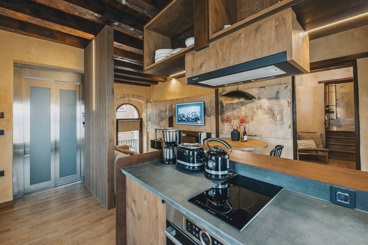 A modern kitchen with a built-in stove, wooden cabinets, and a large island.