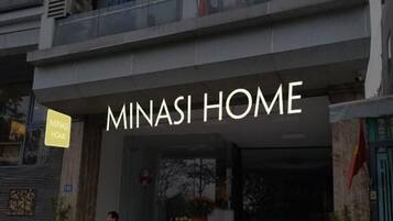 Un edificio con un letrero que dice "MINASI HOME".