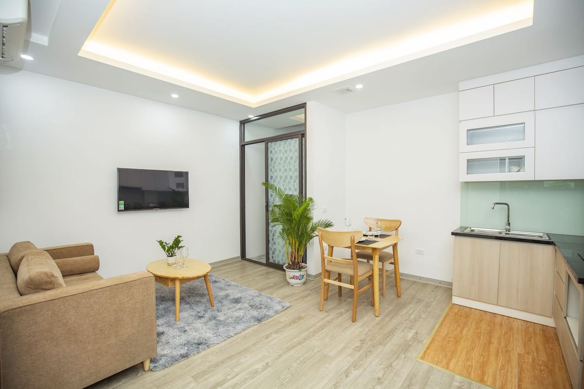 A modern apartment with a living room, dining area, and kitchen.
