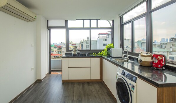 Una cocina moderna con un amplio ventanal, lavadora y tostadora sobre la encimera.