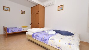A bedroom with two beds, a wardrobe, and an air conditioning unit. - STUDIO ROGULJ, 70m from the beach in Mastrinka (Mastrinka)
