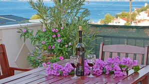 A table with a bottle of wine, two glasses, and purple flowers. - STUDIO ROGULJ, 70m from the beach in Mastrinka (Mastrinka)