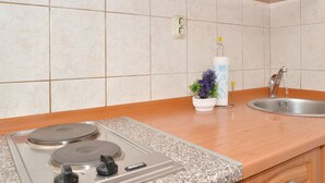 A kitchen with a granite countertop, a stainless steel sink, and a stove. - STUDIO ROGULJ, 70m from the beach in Mastrinka (Mastrinka)
