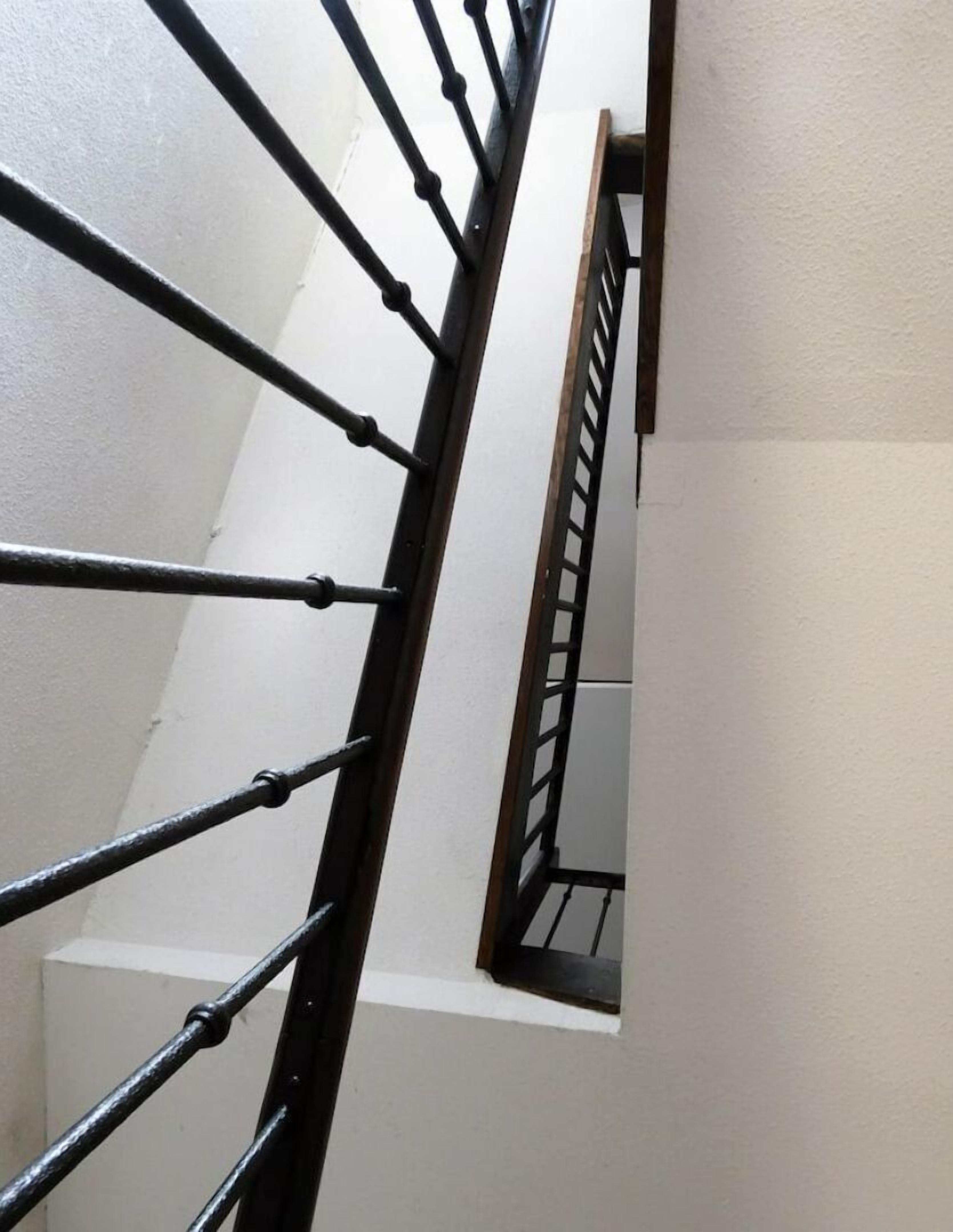 Un escalier avec une rampe en métal et des marches en bois.