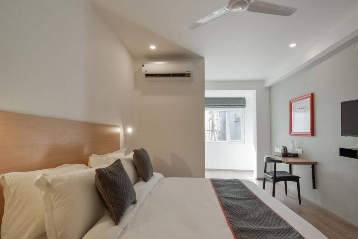 Une chambre d’hôtel avec un lit, une table de chevet, une chaise et une fenêtre donnant sur un paysage agréable.