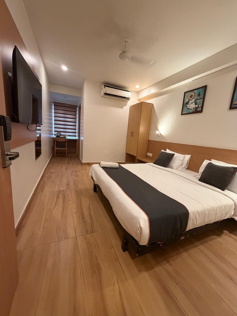 Una habitación de hotel con cama, escritorio, silla y televisión.
