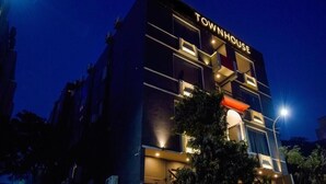 Un edificio de varios pisos con el letrero "TOWNHOUSE" en la parte superior.