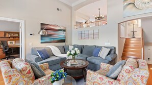 A spacious living room with a grey sofa set, a coffee table, and colorful patterned chairs. - Perfect Mesa Retreat | Remodeled Condo with a Pool (Santa Barbara)