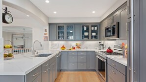 A modern kitchen with grey cabinets, a stainless steel refrigerator, and a microwave. - Perfect Mesa Retreat | Remodeled Condo with a Pool (Santa Barbara)
