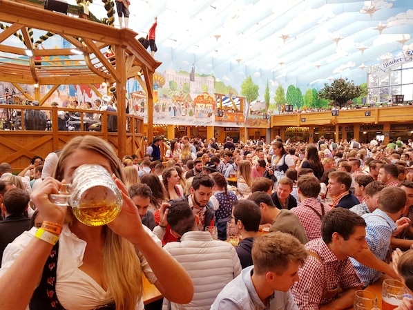 A crowded indoor event with wooden structures and a festive atmosphere. - Munich Central Camping (Munich)