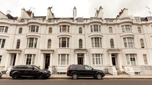 A row of white, multi-story buildings with uniform architectural style, featuring large windows and a symmetrical facade. - Lovely 1 Bedroom With Patio - 10 Mins From Hyde Park (London)