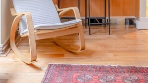 A modern kitchen with wooden cabinets, a microwave, and a built-in oven. There are two wooden chairs and a small rug on the floor. - Lovely 1 Bedroom With Patio - 10 Mins From Hyde Park (London)