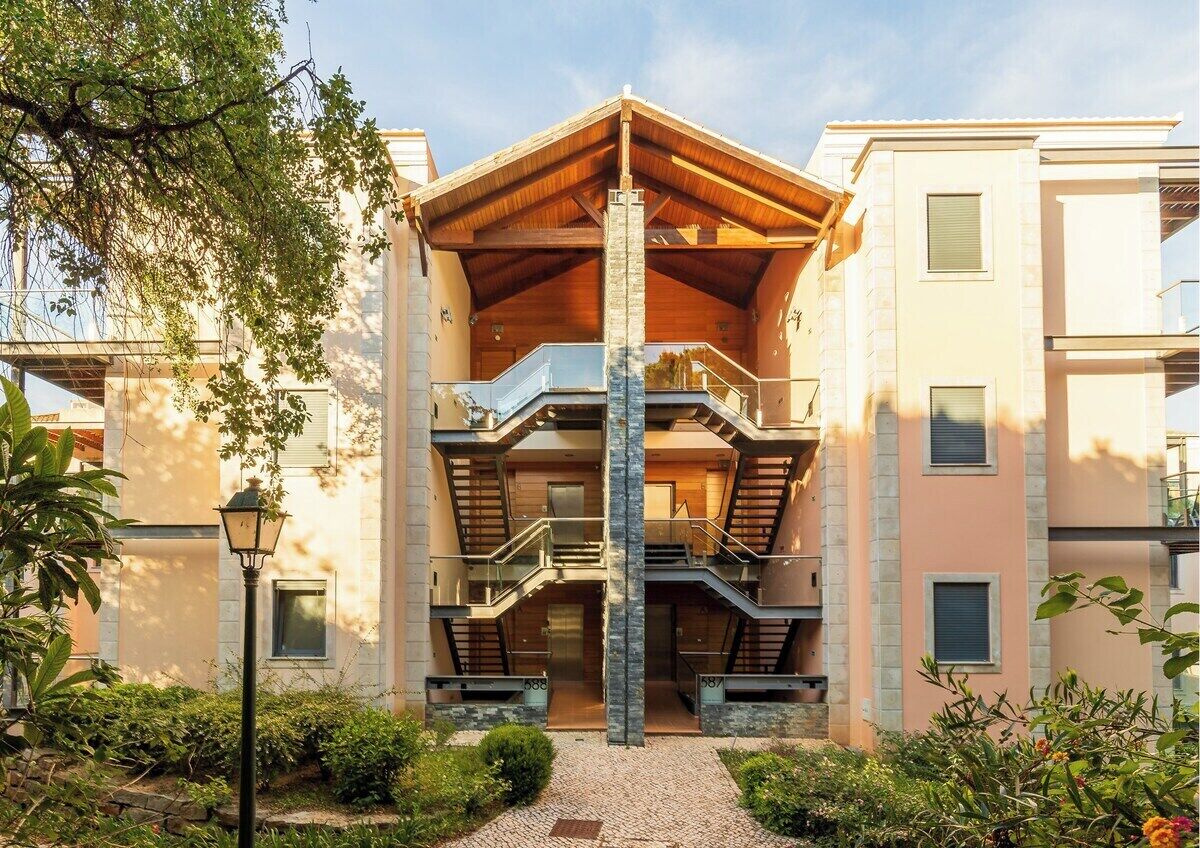 Un edificio de varios pisos con un atrio central, balcones y una escalera.