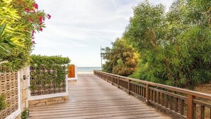 A wooden boardwalk leading to a beach, flanked by greenery and a fence. - Vale Lobo Golf & Beach with Private Pool II (Almancil - VALE DO LOBO)