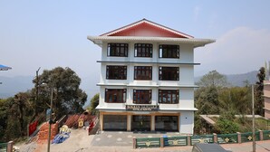 A multi-story hotel with a red roof and white walls, featuring a sign that reads "Sikkim Sarovar Hotel & Resort." - Sikkim Sarovar (Namchi)