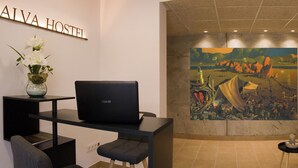 Un moderno vestíbulo de hotel con una recepción, zona de estar y un gran mural en la pared.