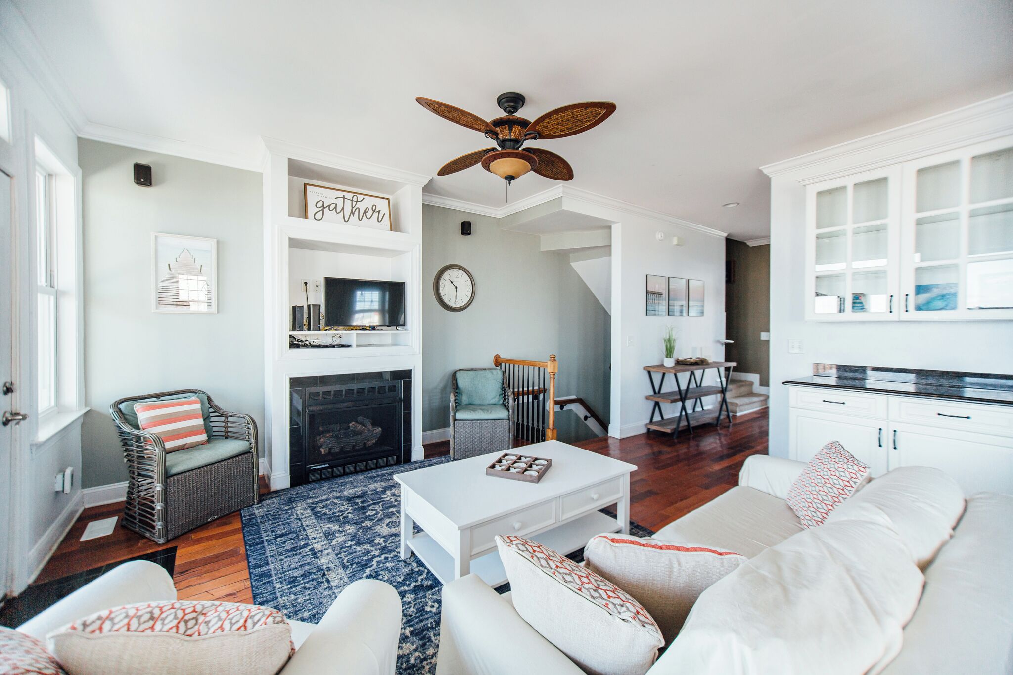 A spacious living room with a fireplace, a dining area, and a kitchen with white cabinets.