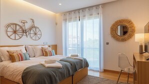 A modern bedroom with a large bed, a desk, and a balcony with curtains. - Vale Lobo  Golf & Beach with Private Pool I (Vale do Lobo)