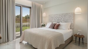 Un dormitorio moderno con una cama grande, vistas al exterior y una original cabecera texturizada.