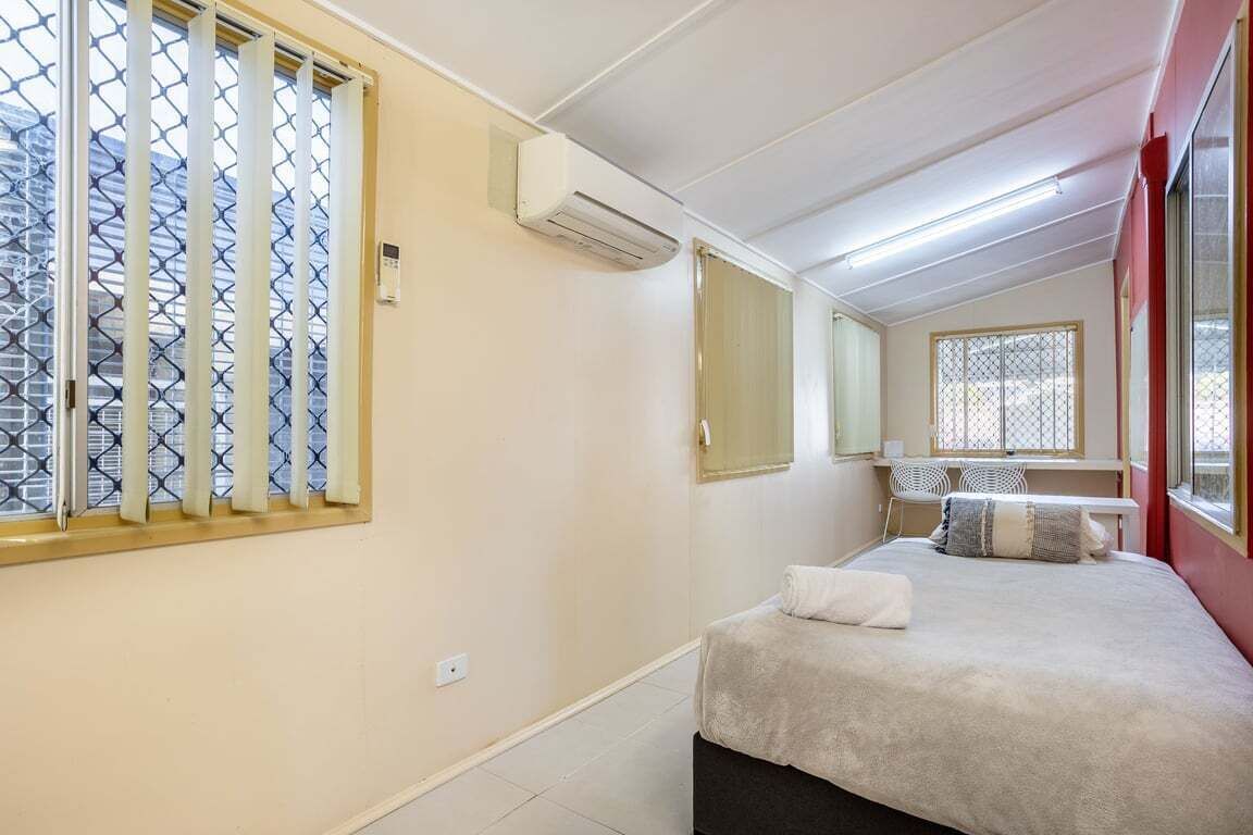 Un dormitorio con cama, escritorio y ventana con vistas.