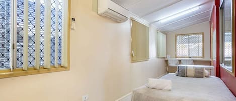 Un dormitorio con cama, escritorio y ventana con vistas.